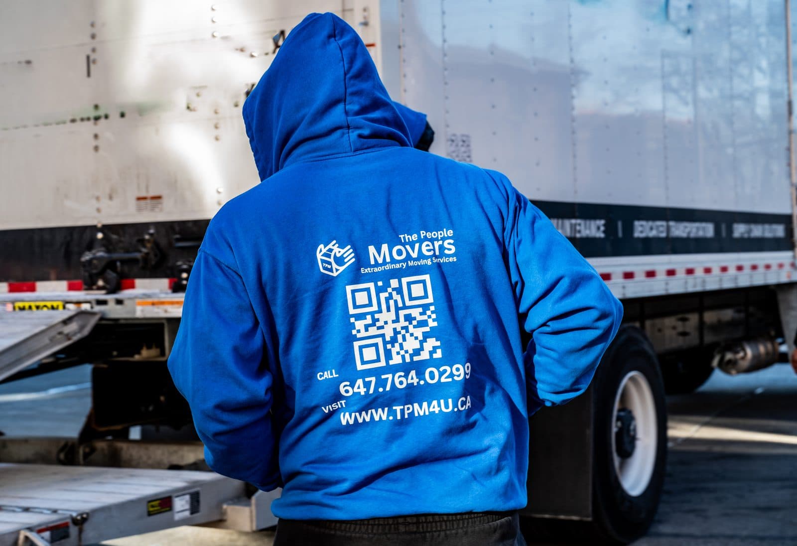 A The People Movers crew member in a branded hoodie loading a moving truck